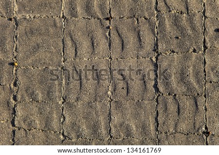 Gray floor tiles with rippled texture lit by afternoon sun. Good as background.
