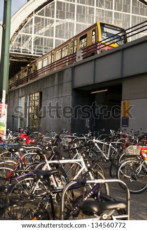 BERLIN - JUNE 12th: Bicycles by the Alexanderplatz S-Bahn station, a yellow train existing the station platform above on June 12 2012 in Berlin, Germany.