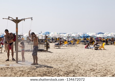 TEL AVIV - AUG 18: The beach packed with people on a hot summer day. Some are in the water, others sunbathing or shade dwelling, on August 18 2012 in Tel Aviv, Israel.