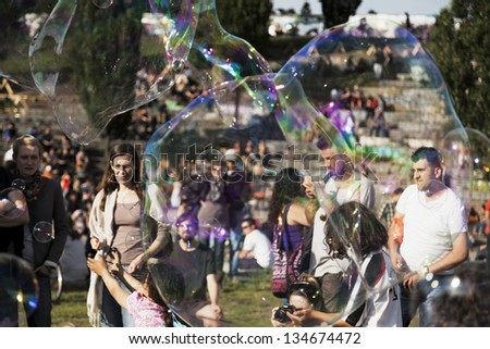 BERLIN - JUNE 10: The crowd at Mauerpark seen through giant soap bubbles on an early summer afternoon. On June 10 2012 in Berlin, Germany.