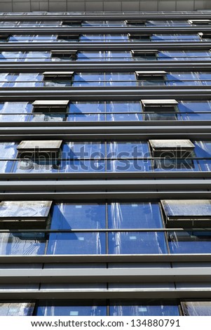 Extreme low angle shot of an office building, with all its dusty windows open.