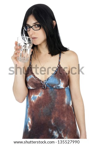 An adult Caucasian woman in her early 30\'s, wearing a casual summer dress and flip-flops, drinking a glass of water while looking at the camera with a serious expression. Isolated on white background.