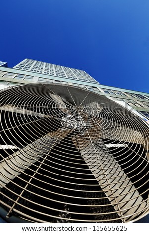 Wide angle view of an outdoor HVAC air conditioner unit located on a high-floor porch of a midtown Manhattan skyscraper.