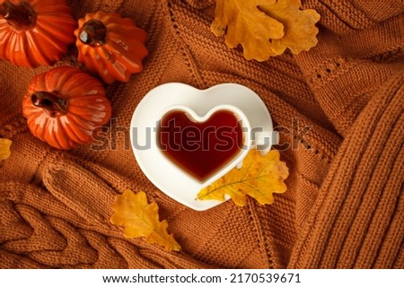Autumn still life. Oak leaves, heart cup on knitted scarf or plaid. Ceramic pumpkin - halloween home decor, concept of love fall season, Warm, cozy, rustic style home decor Foto stock © 