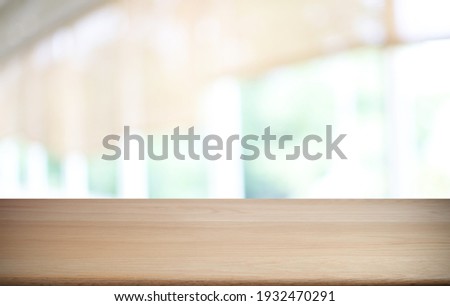 Empty wooden table in front of abstract blurred background of coffee shop . wood table in front can be used for display or montage your products.Mock up for display of product
