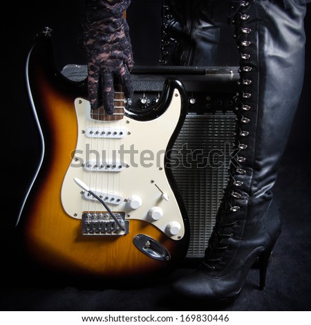 Electric Guitar In Front of Amplifier Picked Up by a Goth Woman