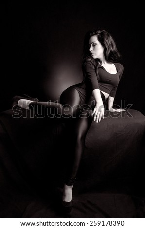 Black and white image of attractive woman giving a sexy pose against a black background