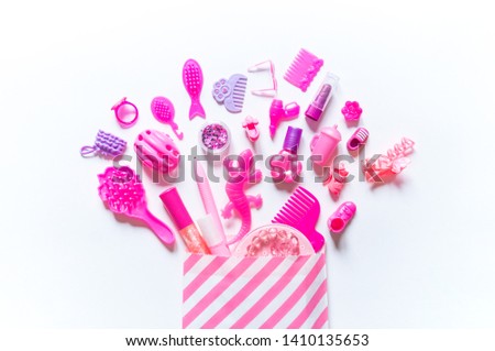 Girly toys for the baby in the pink package. Accessories for dolls. Shoes comb hairpins and varnish. White background Сток-фото © 