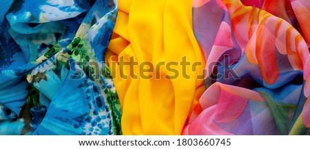 Panorama made of multi-colored fabric. Silk fabric for sewing light clothing. Three types of fabric create the background. Fashionable lightweight silk fabric.