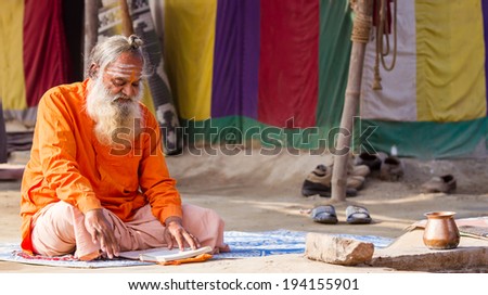 ALLAHABAD, INDIA - FEB 13 - An Hindu priest studies scriptures in front of his tent during the festival of Kumbha Mela on February 13th 2013 at Allahabad, India.