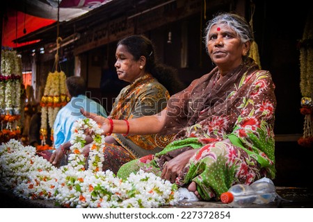 MYSORE, INDIA -  JULY 24th Two ladies selling flower garlands in the Mysore marketplace on 24th July 2010