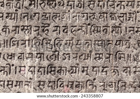 Ancient Sanskrit text etched into a stone tablet.