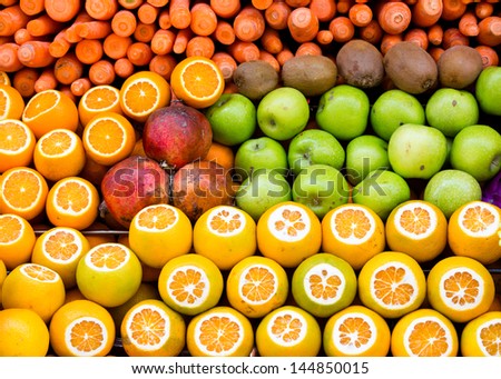 oranges, apples, kiwis, carrots and pomegranates presented at  the weekly fruit market