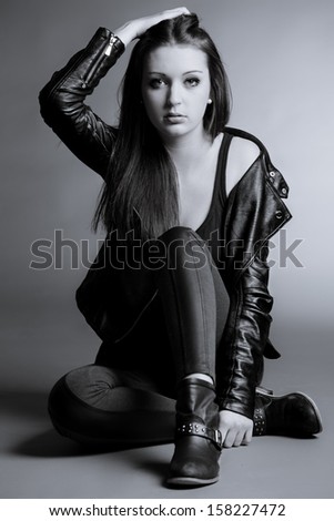beautiful young woman posing in leather jacket, shirt and jeggings
