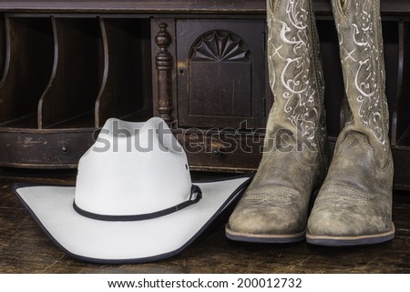 A pair of cowboy boots and hat sitting on a table
