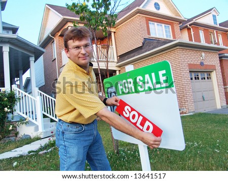 Two story house in a modern suburban neighbourhood with House For Sale Sign. The owner is attaching SOLD sign.