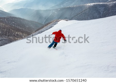 Similar – Image, Stock Photo Skier with red jacket and green backpack in icy snowy landscape walks on lonely ski track on way to mountain in evening light