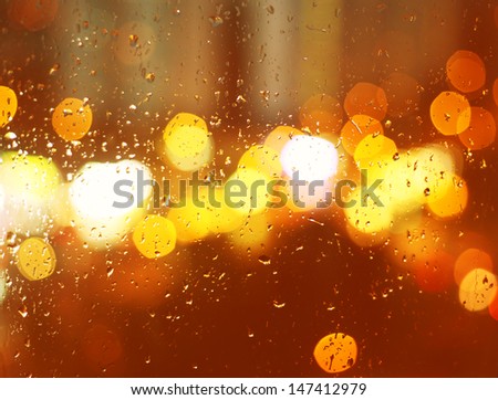 Image of raindrops on window at night in the city