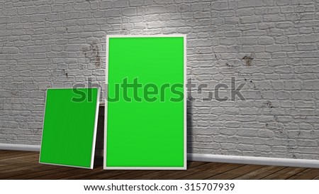 two green screen frames in front of brick wall on wooden floor illuminated with spotlight