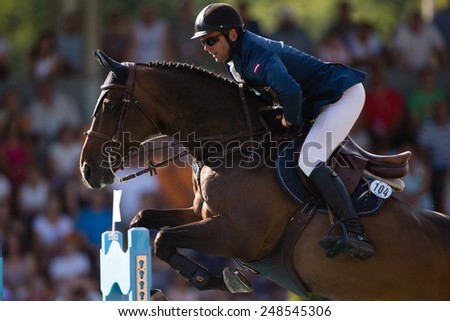 RIGA, LATVIA - JULY 27: Andis Varna with horse Never Mind (22) jumps over obstacle at World Cup qualifying round CSI2*-W/CSIYH1* RIGA-2014 on JULY 27, 2014 in RIGA