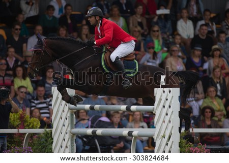 RIGA, LATVIA - Aug  2: Rider Urmas RAAG (EST) with horse CARLOS (64)  jumps over obstacle at FEI World Cup Qualifying competition CSI2*-W and Qualifier for 2016 Olympic Games on August 2, 2015 in Riga