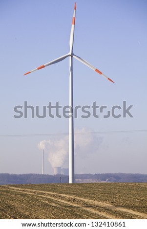 wind power generation with coal burning power plant in the background
