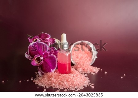 Bottle of rose essential oil, bath salt and phalaenopsis on vinous background Photo stock © 