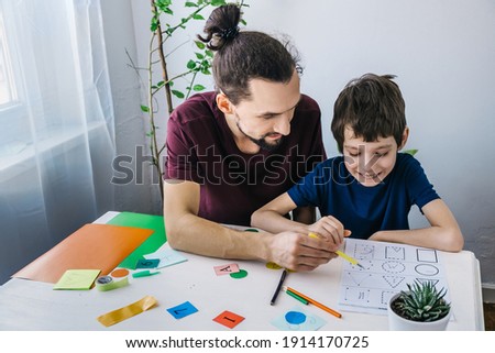 Autistic boy during therapy at home with his father with learning and having fun together. Autism awareness concept