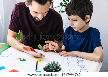 Similar – Image, Stock Photo Boy with Autism communicating with ipad while eating a homemade gluten free muffin; plastic animal toys nearby