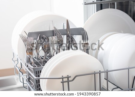 Dishes and cutlery on dishwashing machine. Clean dishes