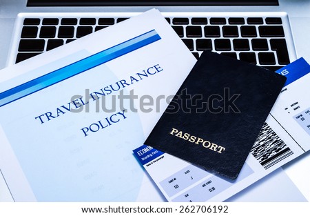 Travel insurance policy booklet with a boarding pass and a passport