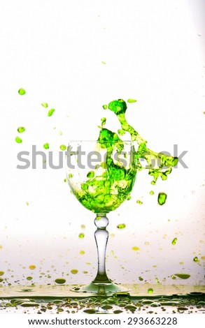 Glass of green fresh water, Water flows into the glass make splash isolated on a white background, water drop splash on white background