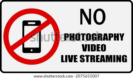 No photography, video or live streaming. Prohibition sign with a smartphone inside the ban circle and text.
