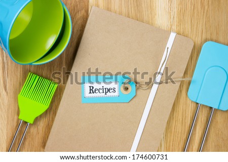 top-view of a recipe book with kitchen utensils such as bowls, pastry brush