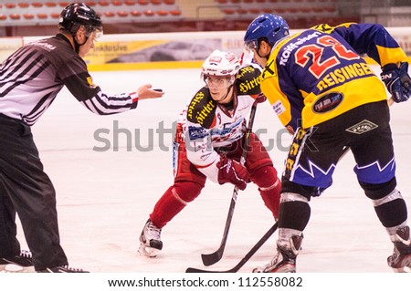 ZELL AM SEE, AUSTRIA - AUGUST 28: Hockey game between EK Zell am See and KAC Young Stars. Referee drops the puck for the face off on August 28, 2012 in Eisbaeren Arena, Zell am See, Austria
