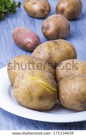 boiled potatoes in their skins, raw potatoes and parsley