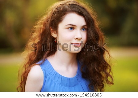 Blue-eyed Teenager looking right. Beauty portrait of a gorgeous young woman with blue eyes & fabulous hair, smiling & looking to right. Processed from RAW, detailed retouching.