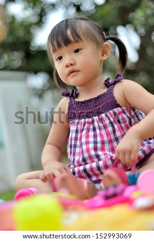 little girl plays cook in garden