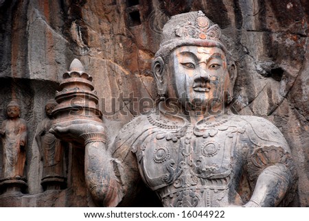 The stone sculpture of the Buddhist warrior with a tower in hand in a grotto of Luoyang,Henan,China.