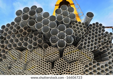 The pile of seamless steel tubes of different calibers and sizes under the blue sky.