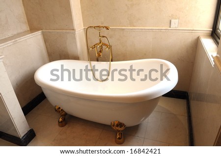 The boat shaped white ceramic tub in the bathroom.