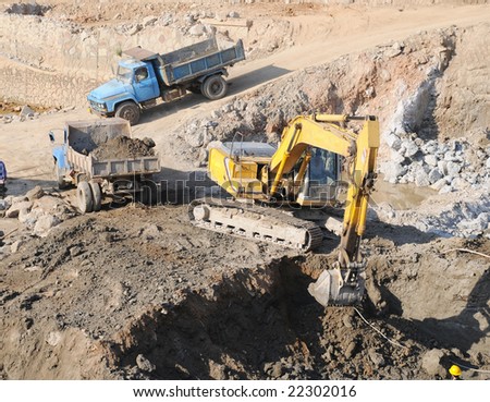 The construction site lorry and earth excavator machine.