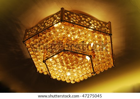 Golden hexagon pendant lamp on ceiling of a luxury restaurant.