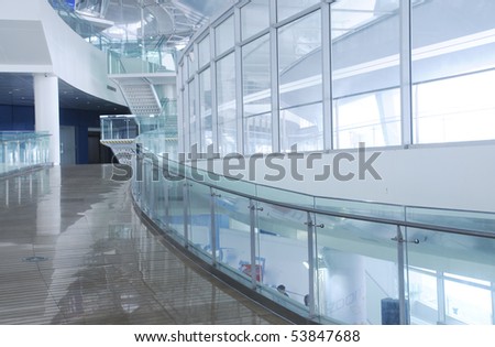 Corridor with glass fencing and glass wall in a modern building.