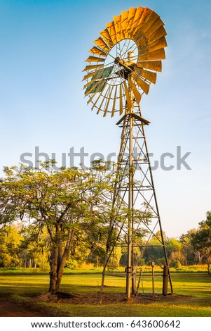 Similar – Image, Stock Photo Long shadow under windmill, large wind power turbines spinning to generating clean, green, renewable energy