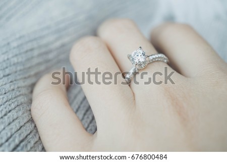  Close up of elegant diamond ring on the finger with gray Scarf background. Diamond ring. Imagine de stoc © 