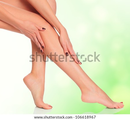 Attractive female legs on green blurred background