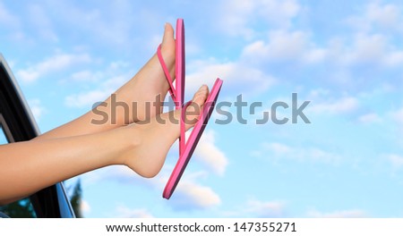 Female legs in pink sandals out from the car. Summer trip concept