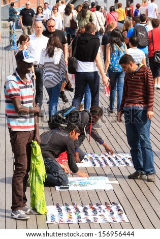 BARCELONA, SPAIN - APRIL 16 : Street market in port Vell on April 16, 2013 Barcelona. People buying and selling sunglasses, and souvenirs on the main pier of the port Vell, oldest port of Barcelona