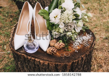 Wedding accessories and details of the bride on a stump, top view: leather shoes, bouquet, rings, cones, hairpin, perfume. Female set close-up, photography. Сток-фото © 